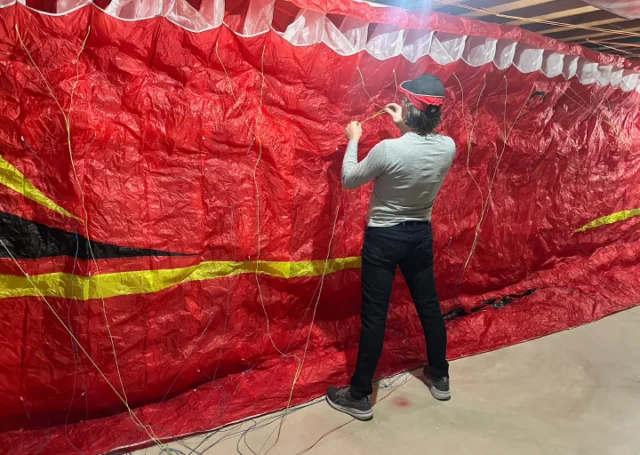 Técnico haciendo comprobacion sobre cordines de un parapente